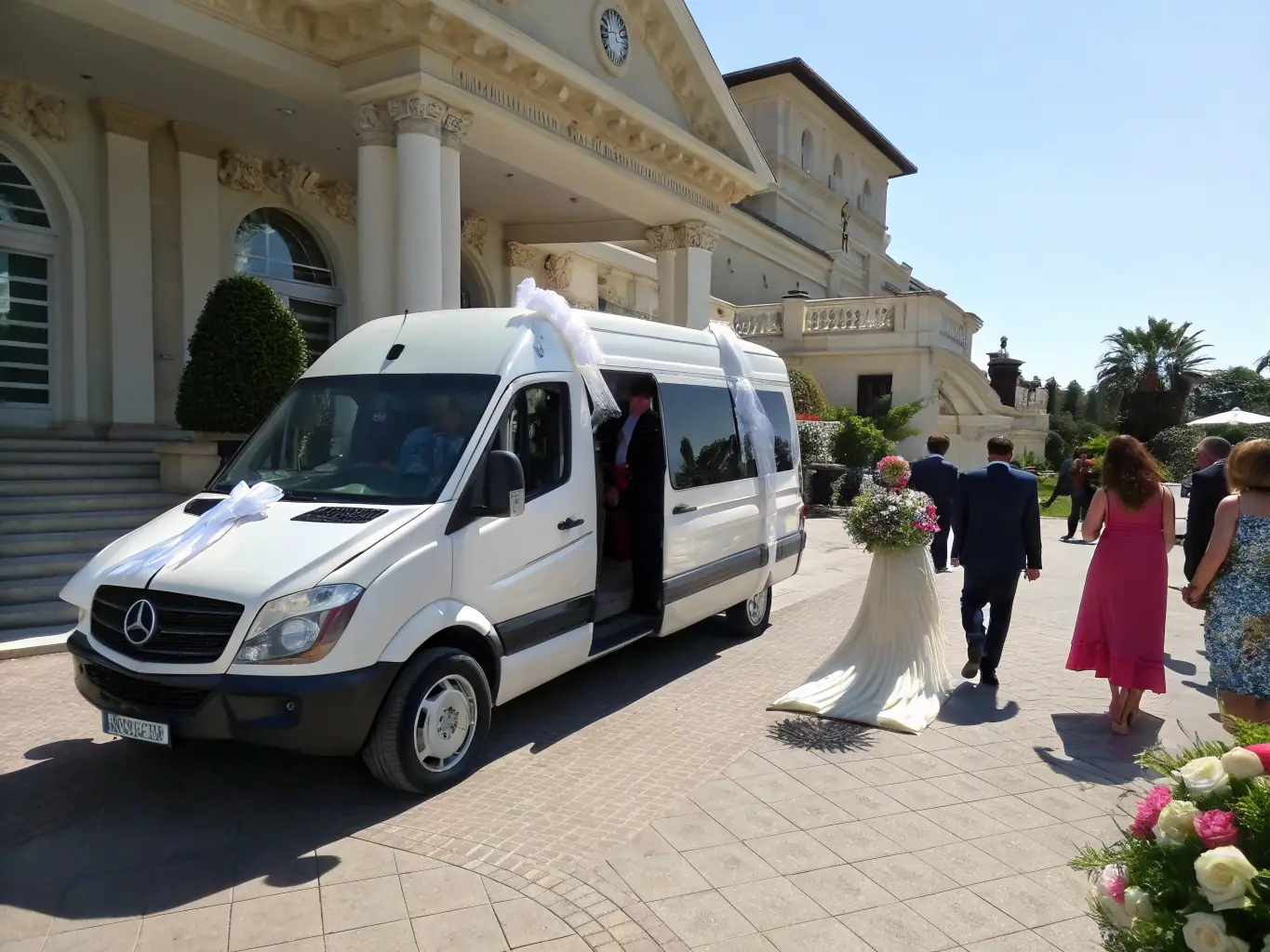 A spacious white Sprinter van is decorated with ribbons and flowers, parked in front of a picturesque wedding venue in Montréal. The scene evokes elegance and celebration.